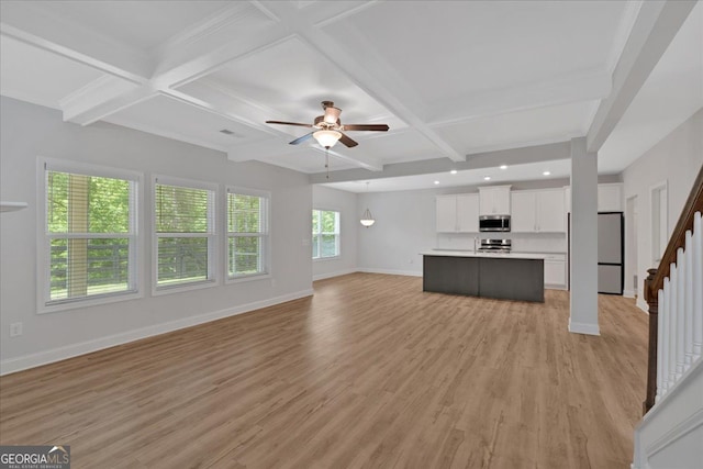 unfurnished living room featuring baseboards, a ceiling fan, light wood-type flooring, beam ceiling, and coffered ceiling