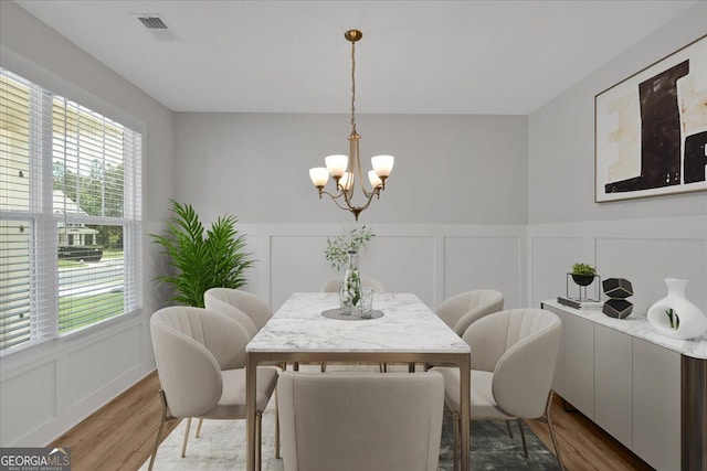 116 Daffodil Lndg, Dallas, GA 30132 - dining space with a decorative wall, a chandelier, wood finished floors, and a wainscoted wall