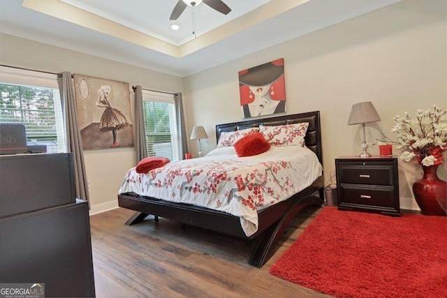 233 Isabella Way, Jesup, GA 31546 - bedroom with wood finished floors, multiple windows, a tray ceiling, ornamental molding, and baseboards