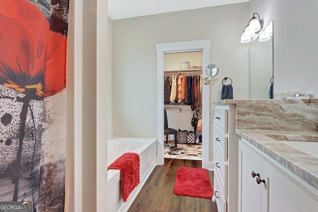 233 Isabella Way, Jesup, GA 31546 - full bathroom featuring wood finished floors, vanity, a garden tub, and a spacious closet