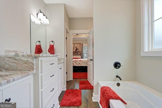 233 Isabella Way, Jesup, GA 31546 - ensuite bathroom featuring wood finished floors, a tub to relax in, healthy amount of natural light, and vanity