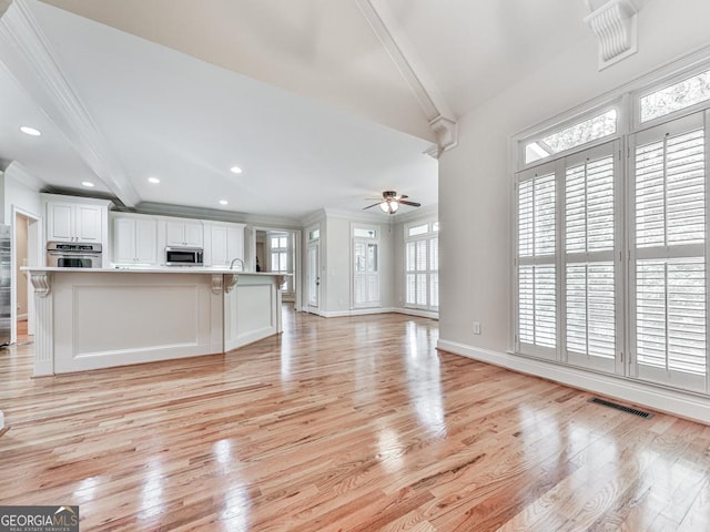 414 Candler Trl, Canton, GA 30115 - unfurnished living room with crown molding, plenty of natural light, light wood-style flooring, ceiling fan, and recessed lighting