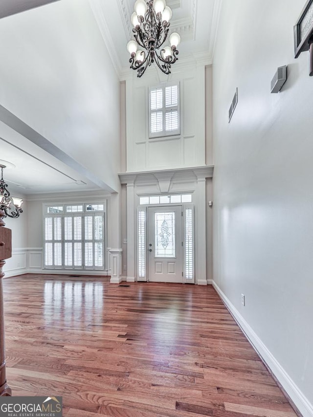 414 Candler Trl, Canton, GA 30115 - foyer entrance featuring a chandelier, crown molding, a high ceiling, wood finished floors, and a decorative wall