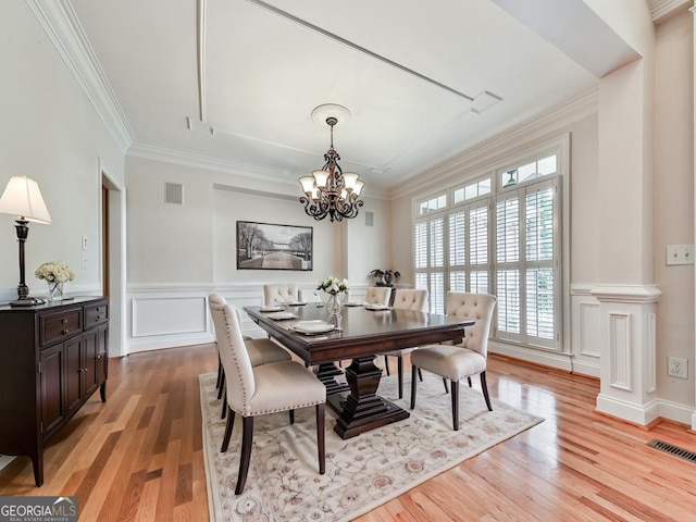 414 Candler Trl, Canton, GA 30115 - dining area with crown molding, a chandelier, light wood-style floors, wainscoting, and a decorative wall