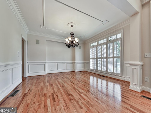 414 Candler Trl, Canton, GA 30115 - spare room with a chandelier, light wood-style floors, crown molding, a decorative wall, and wainscoting