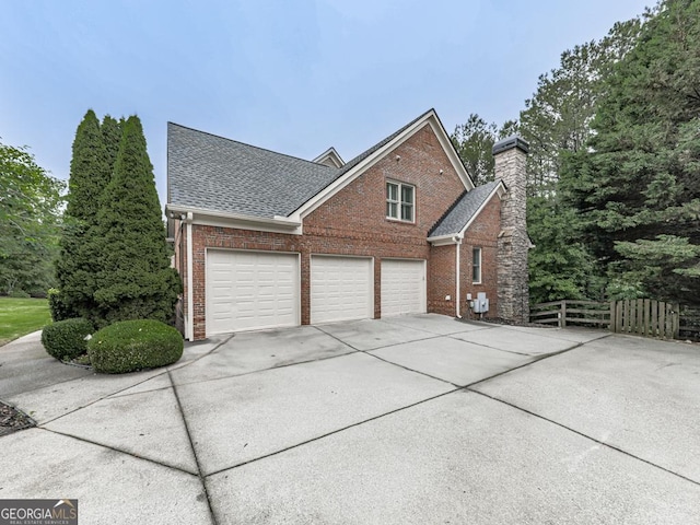 414 Candler Trl, Canton, GA 30115 - view of property exterior featuring brick siding, driveway, roof with shingles, and a chimney