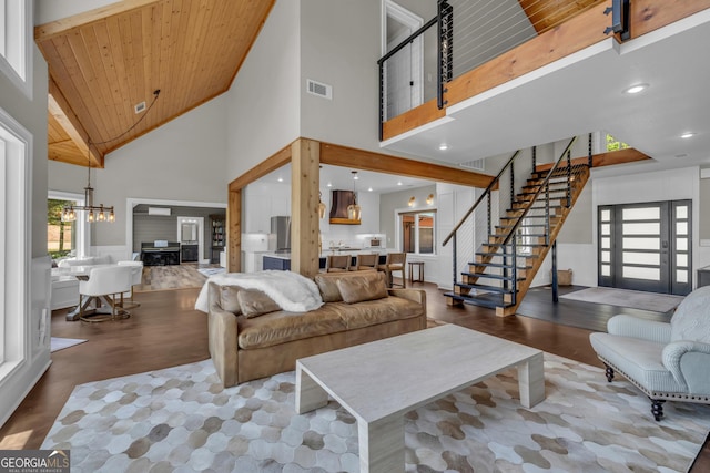 living room with high vaulted ceiling, a chandelier, wood finished floors, stairway, and wooden ceiling
