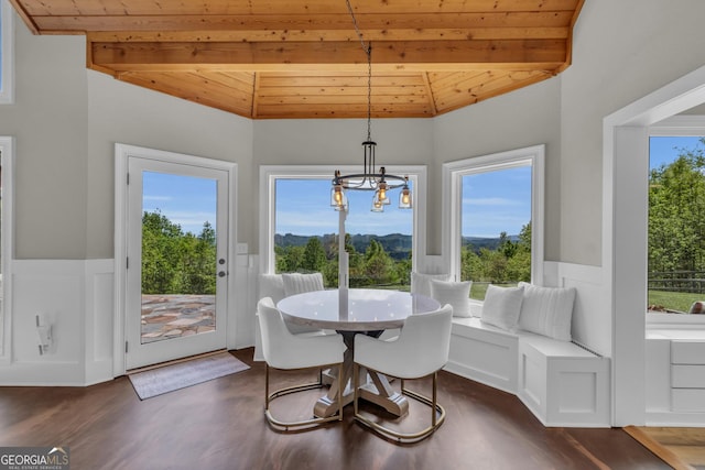 dining room with wooden ceiling, a wainscoted wall, dark wood-style flooring, and a chandelier