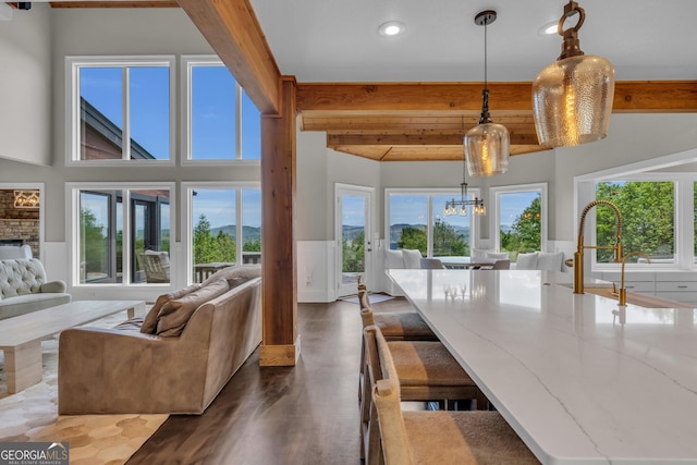 sunroom with beam ceiling, a chandelier, and a sink