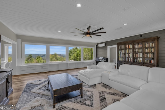 living area with ceiling fan, light wood finished floors, recessed lighting, a wall unit AC, and wood ceiling