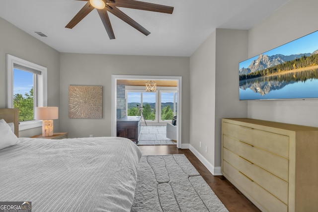 bedroom with multiple windows, baseboards, a chandelier, and ceiling fan