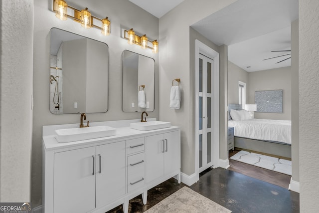 full bathroom featuring connected bathroom, baseboards, double vanity, and finished concrete flooring