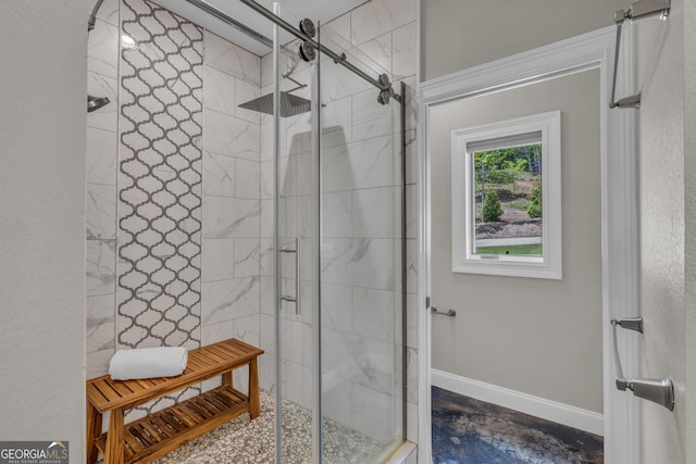 full bath featuring a shower stall and baseboards