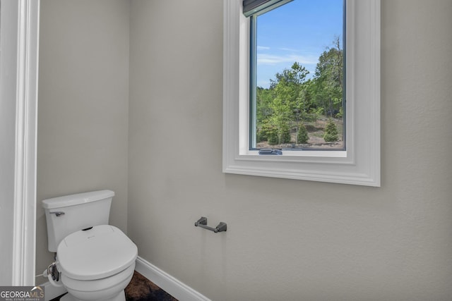 bathroom featuring baseboards and toilet