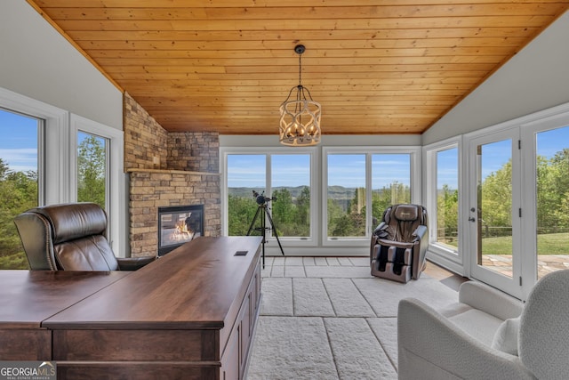 living area with lofted ceiling, wood ceiling, healthy amount of natural light, a fireplace, and a chandelier