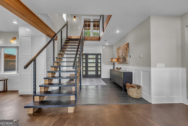 stairs featuring a decorative wall, a wainscoted wall, wood finished floors, and recessed lighting