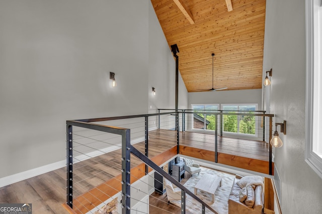 stairs featuring wood ceiling, high vaulted ceiling, beam ceiling, ceiling fan, and baseboards