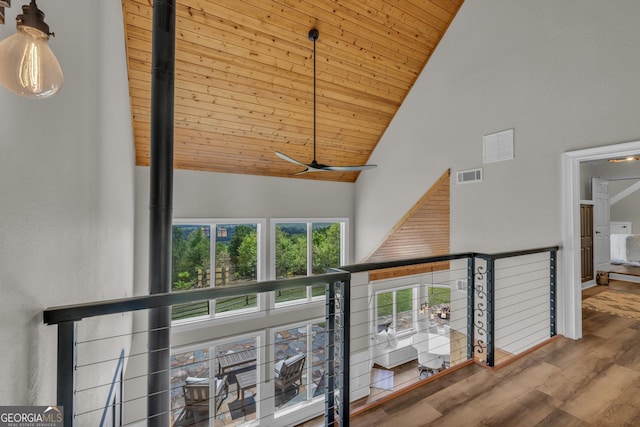 hallway featuring high vaulted ceiling, wooden ceiling, and wood finished floors