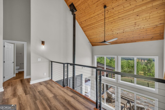 hall featuring high vaulted ceiling, wooden ceiling, baseboards, and wood finished floors