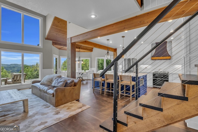 living room with recessed lighting, stairs, beamed ceiling, a high ceiling, and a mountain view