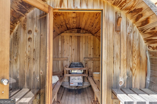 relaxing sauna featuring wood walls and hardwood / wood-style floors