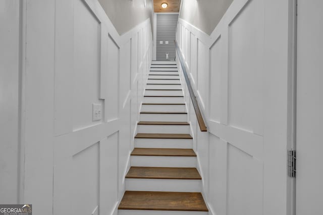 stairs featuring a wainscoted wall and a decorative wall