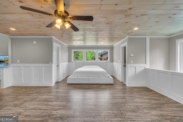 unfurnished bedroom featuring crown molding, wooden ceiling, wainscoting, a decorative wall, and wood finished floors