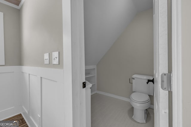 bathroom featuring lofted ceiling and toilet