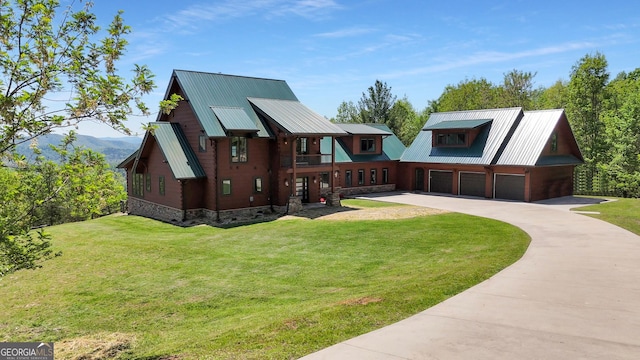 view of front of home with a front lawn, concrete driveway, and metal roof