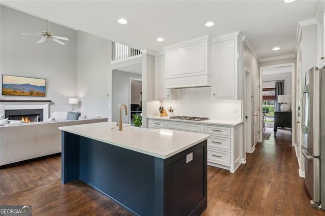kitchen with stainless steel appliances, open floor plan, light countertops, white cabinets, and recessed lighting