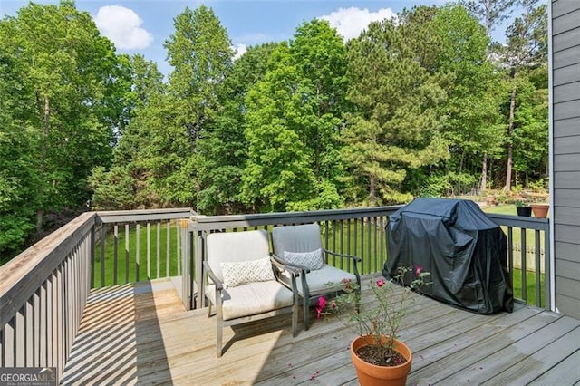 wooden deck with a grill and a yard