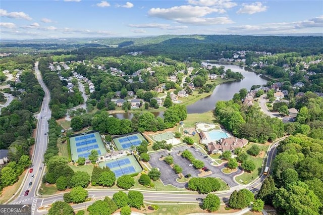 view of property location with a large body of water and a heavily wooded area