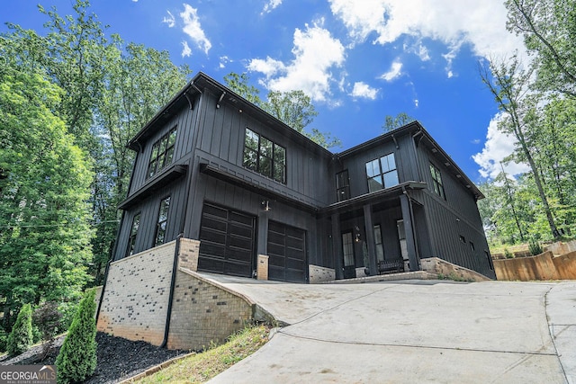 4276 Lindsey Way NE, Roswell, GA 30075 - view of front of house featuring a garage, driveway, fence, board and batten siding, and brick siding