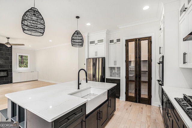 4276 Lindsey Way NE, Roswell, GA 30075 - kitchen with freestanding refrigerator, crown molding, white cabinets, light wood finished floors, and a ceiling fan