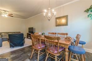 dining room with crown molding, wood finished floors, a chandelier, a ceiling fan, and baseboards
