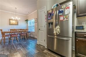 kitchen with stainless steel refrigerator with ice dispenser, ornamental molding, a chandelier, dark wood-style flooring, and baseboards