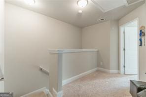 corridor with an upstairs landing, carpet flooring, and baseboards