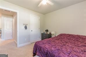 bedroom featuring light colored carpet, baseboards, and ceiling fan