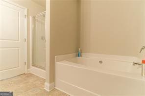 bathroom featuring a shower stall, a bath, and tile patterned floors
