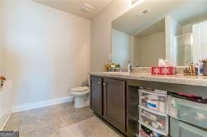 bathroom with toilet, baseboards, double vanity, and a shower