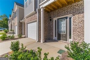 entrance to property with brick siding and an attached garage