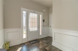 entryway with wainscoting, a decorative wall, and dark wood-type flooring