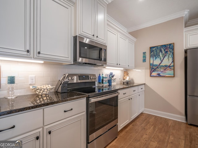 137 Ryan Nicholas Dr, Kingsland, GA 31548 - kitchen featuring stainless steel appliances, crown molding, light wood finished floors, white cabinets, and baseboards