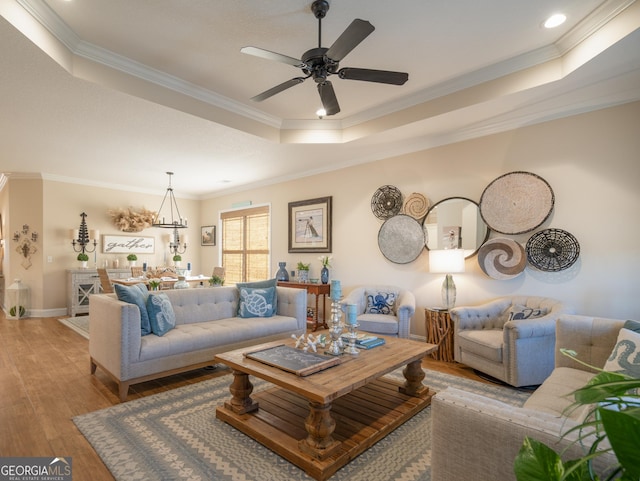 137 Ryan Nicholas Dr, Kingsland, GA 31548 - living area featuring a raised ceiling, wood finished floors, crown molding, a ceiling fan, and baseboards