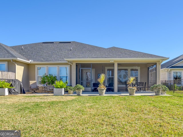 137 Ryan Nicholas Dr, Kingsland, GA 31548 - back of house featuring stucco siding, a sunroom, and a shingled roof