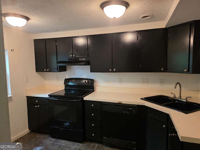 kitchen featuring black appliances, a sink, a textured ceiling, dark cabinetry, and under cabinet range hood