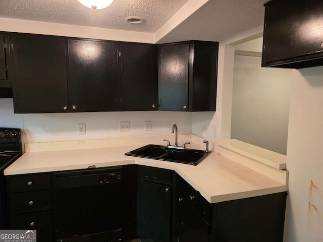 kitchen featuring dark cabinets, a sink, black appliances, a textured ceiling, and light countertops