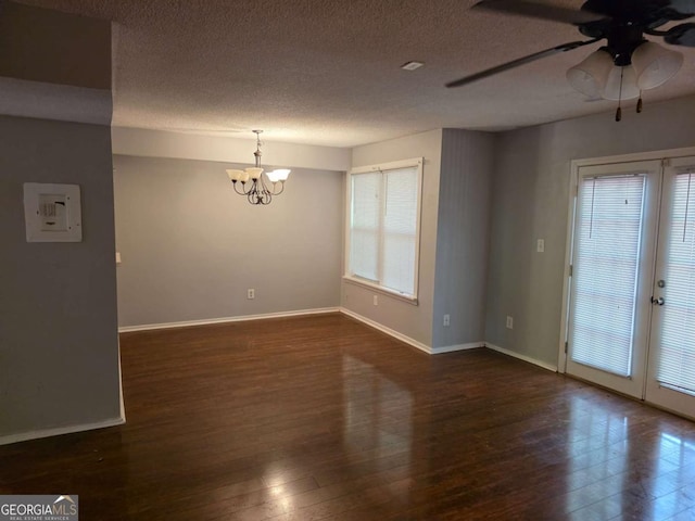 spare room featuring a chandelier, dark wood-style flooring, a ceiling fan, a textured ceiling, and baseboards