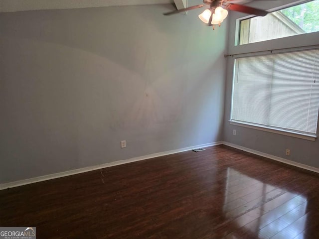 empty room with wood finished floors, ceiling fan, baseboards, and vaulted ceiling