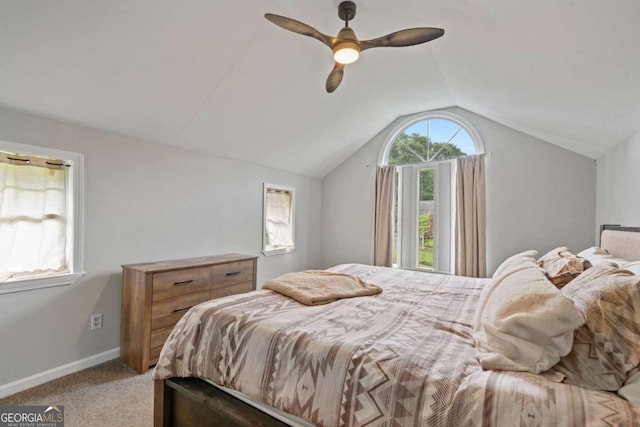 carpeted bedroom featuring vaulted ceiling, baseboards, and a ceiling fan